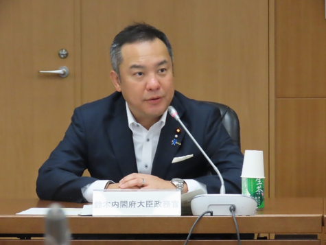 写真： 挨拶する鈴木政務官