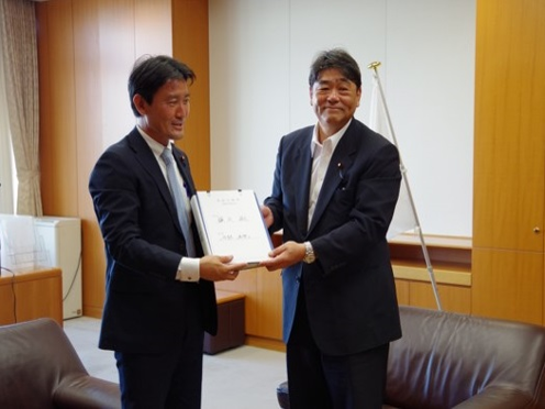 写真：井林内閣府副大臣（左）と藤丸 前内閣府副大臣（右）の引継ぎの模様