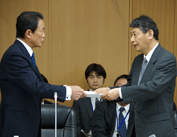 10月23日 第35回金融審議会総会・第23回金融分科会合同会合にて諮問書を岩原会長に手交する麻生大臣